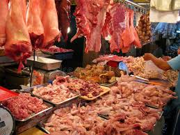 Wet market stall with fresh produce including rice, dried fish, beans and grains displayed